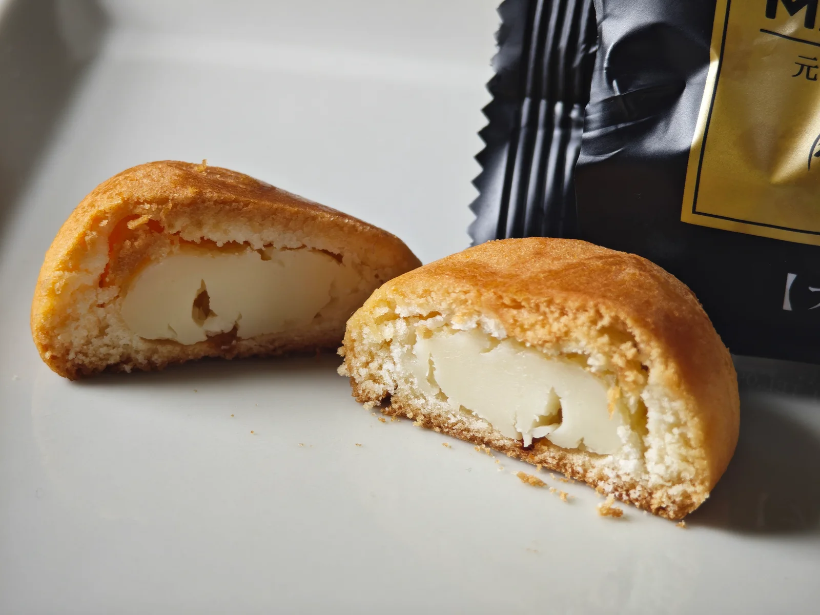 Cross-section of Fugetsudo bite-size cheese manju showing dough and cheese
