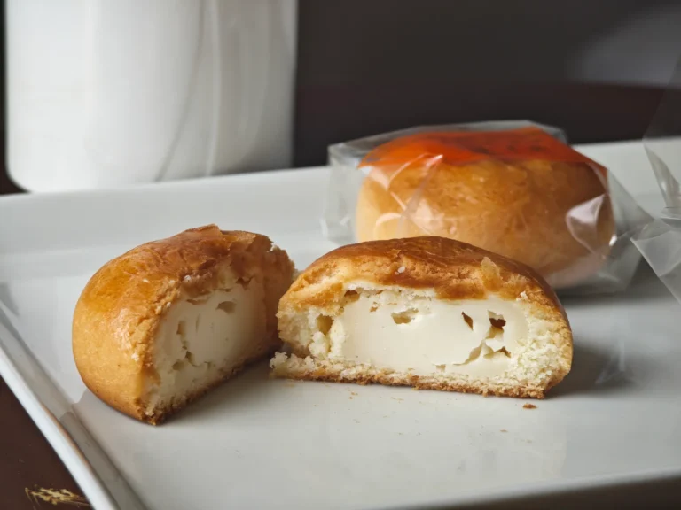 Two cut halves of Fugetsudo Original Cheese Manju showing the cheese filling