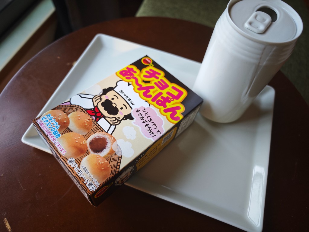 Bourbon Choco Anpan box on a white plate beside a drink
