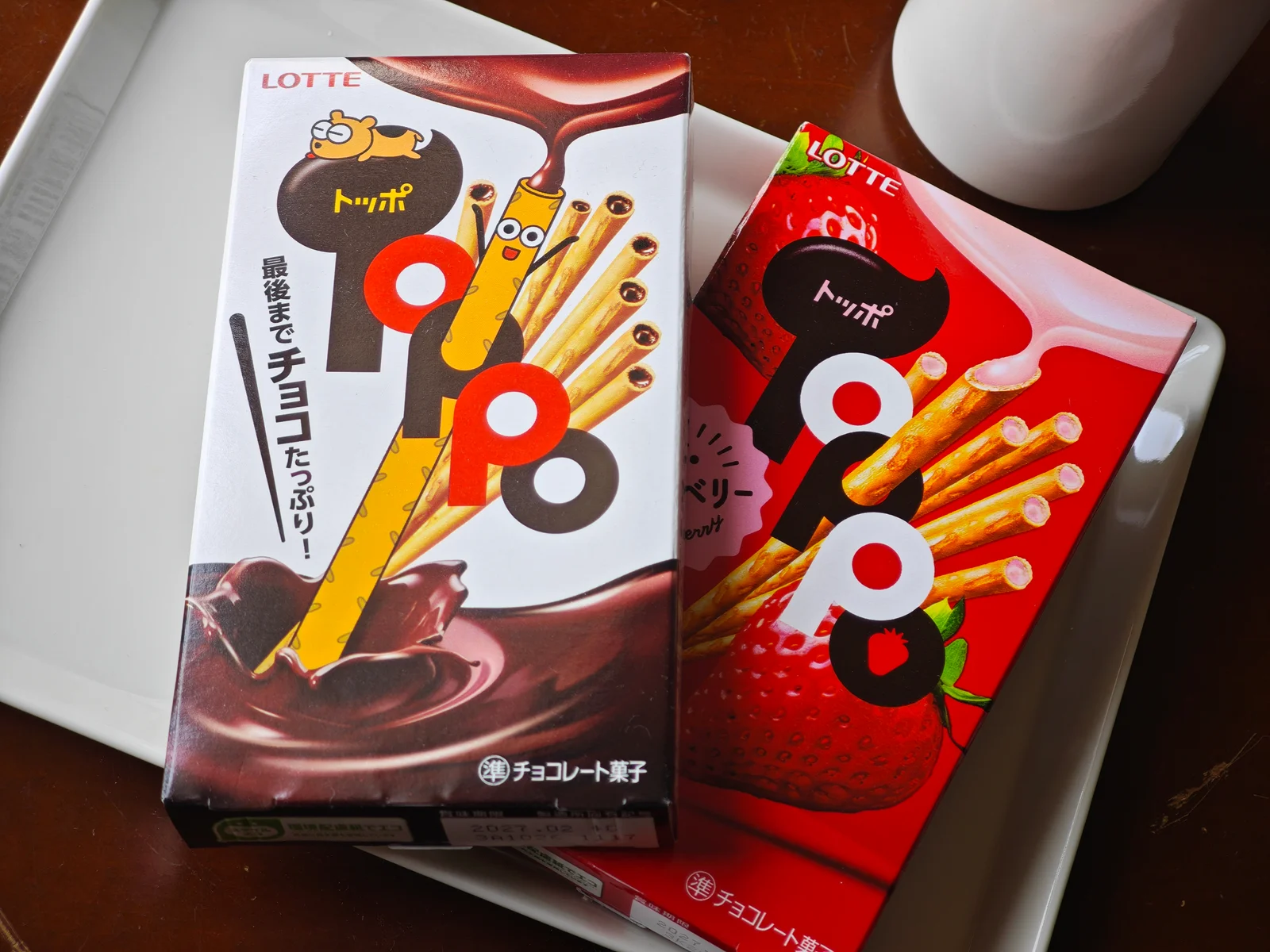 Classic chocolate Toppo and strawberry Toppo boxes side by side on a plate