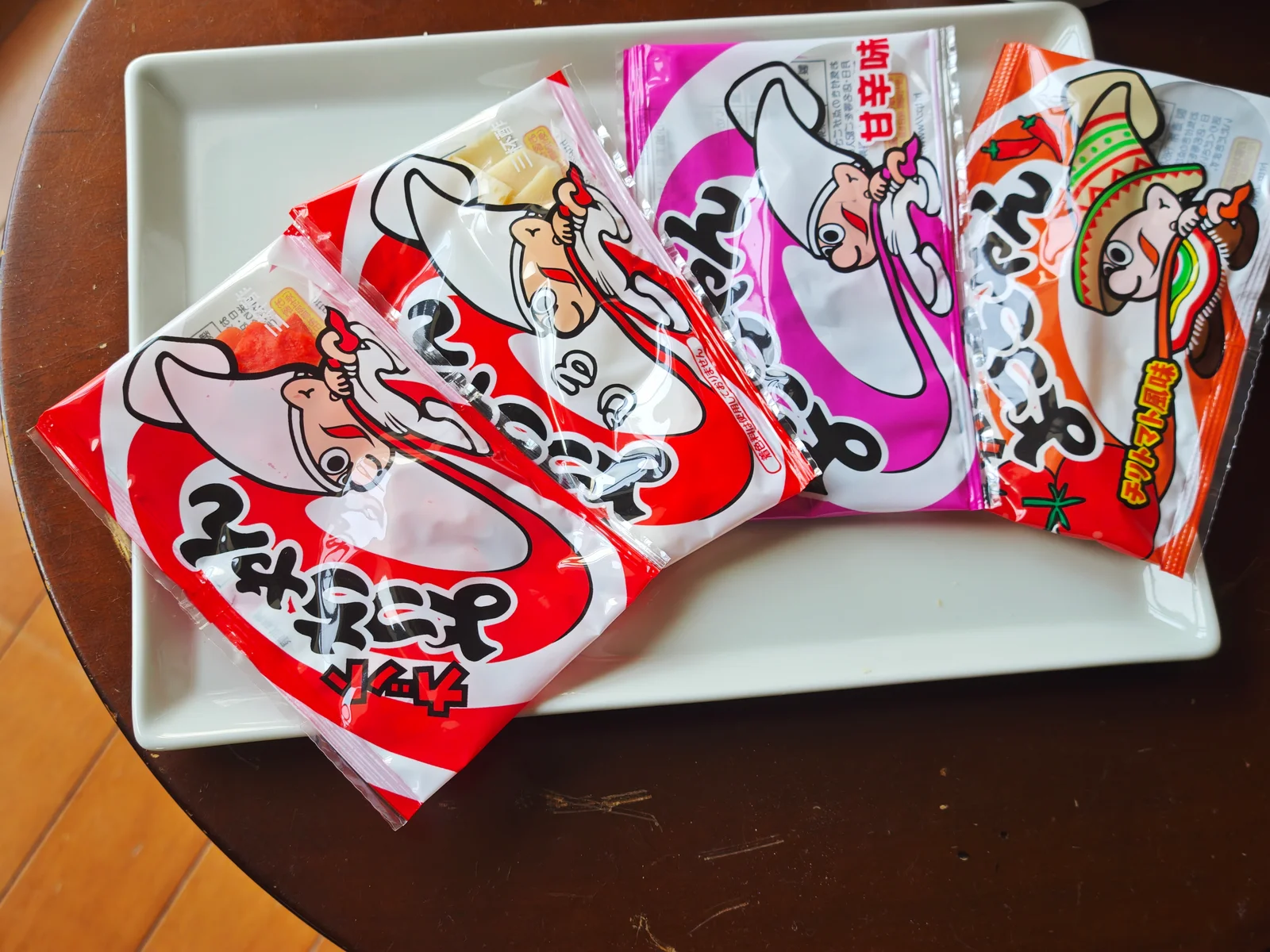 Four Cut Yocchan 10g packs—red, white, sweet-spicy, and chili tomato—lined up on a plate