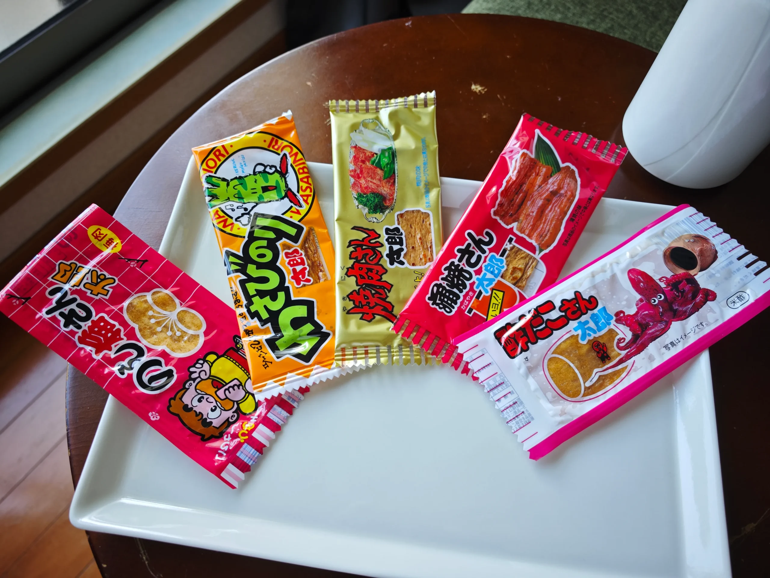 Five San Taro flavor packs on a white plate