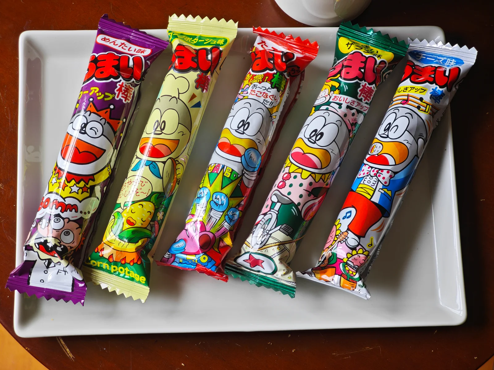 Five wrapped Umaibo flavors arranged together on a plate