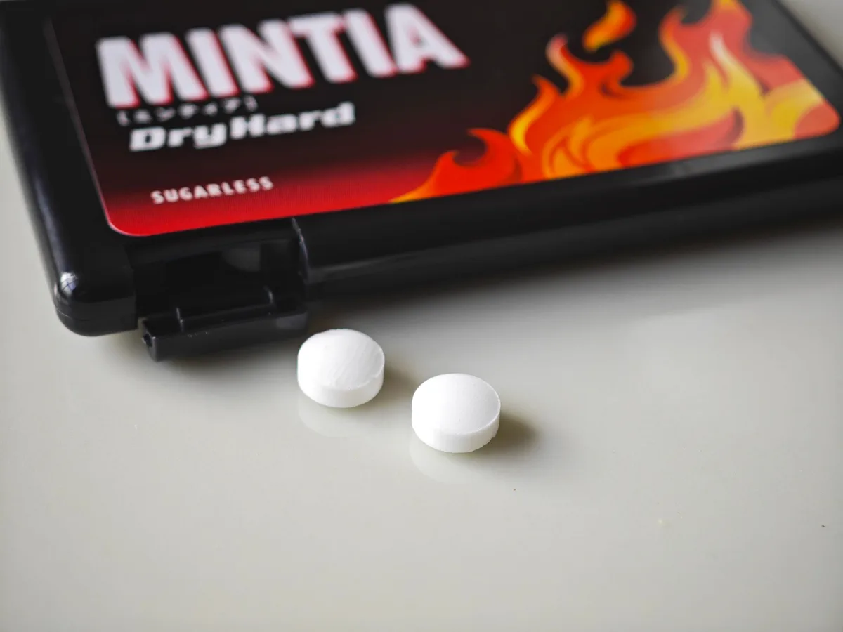 Two MINTIA Dry Hard tablets beside the black flame-printed case