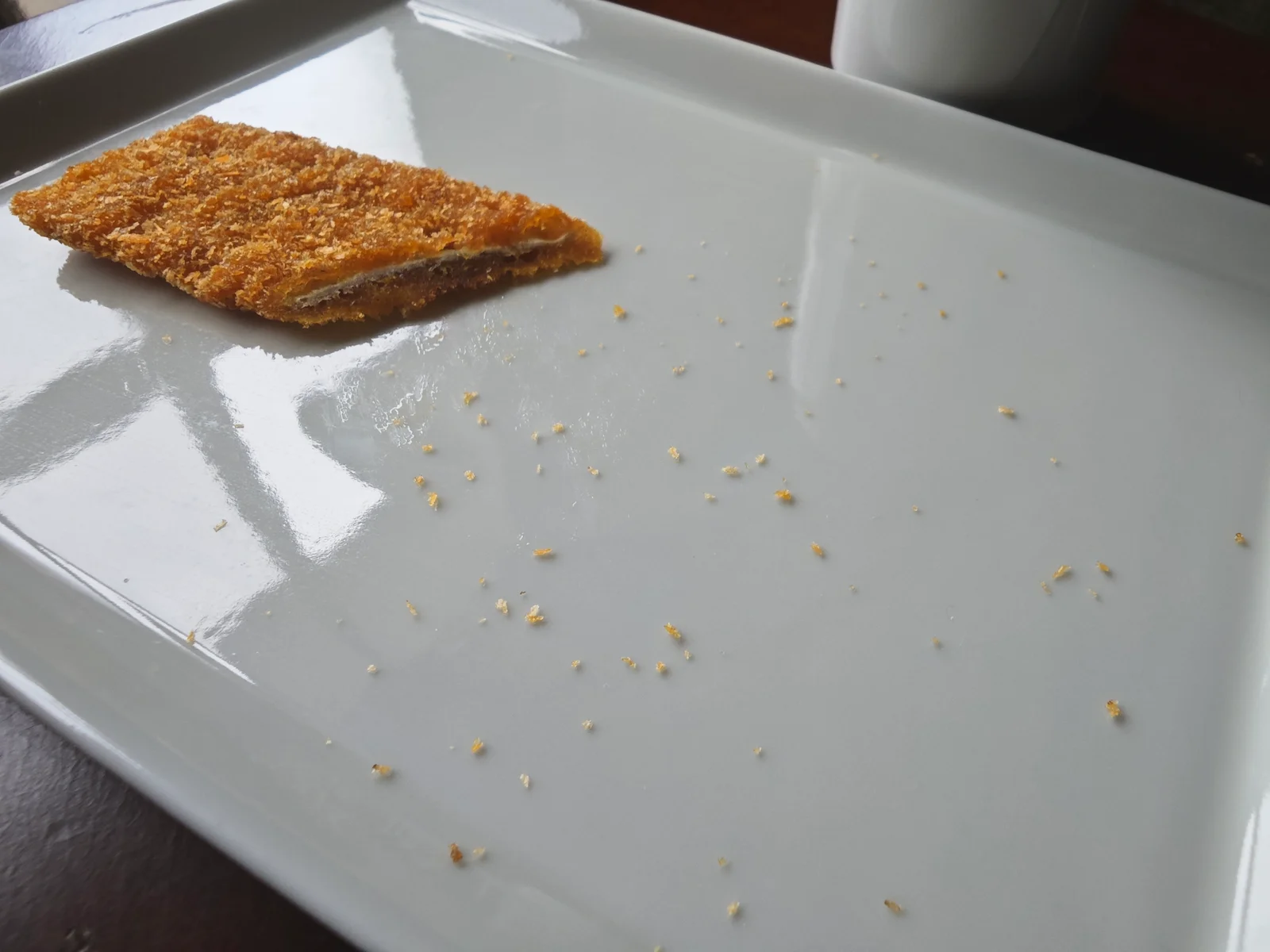 Breadcrumbs scattered across a plate after Big Katsu