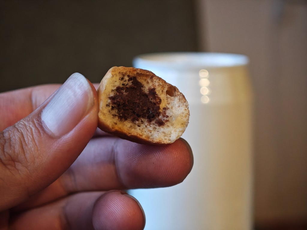 Bitten Choco Anpan held up to show bread and chocolate