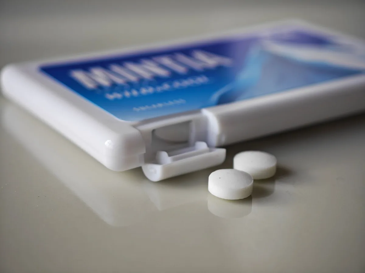 Two MINTIA Wild & Cool tablets beside the pale blue case