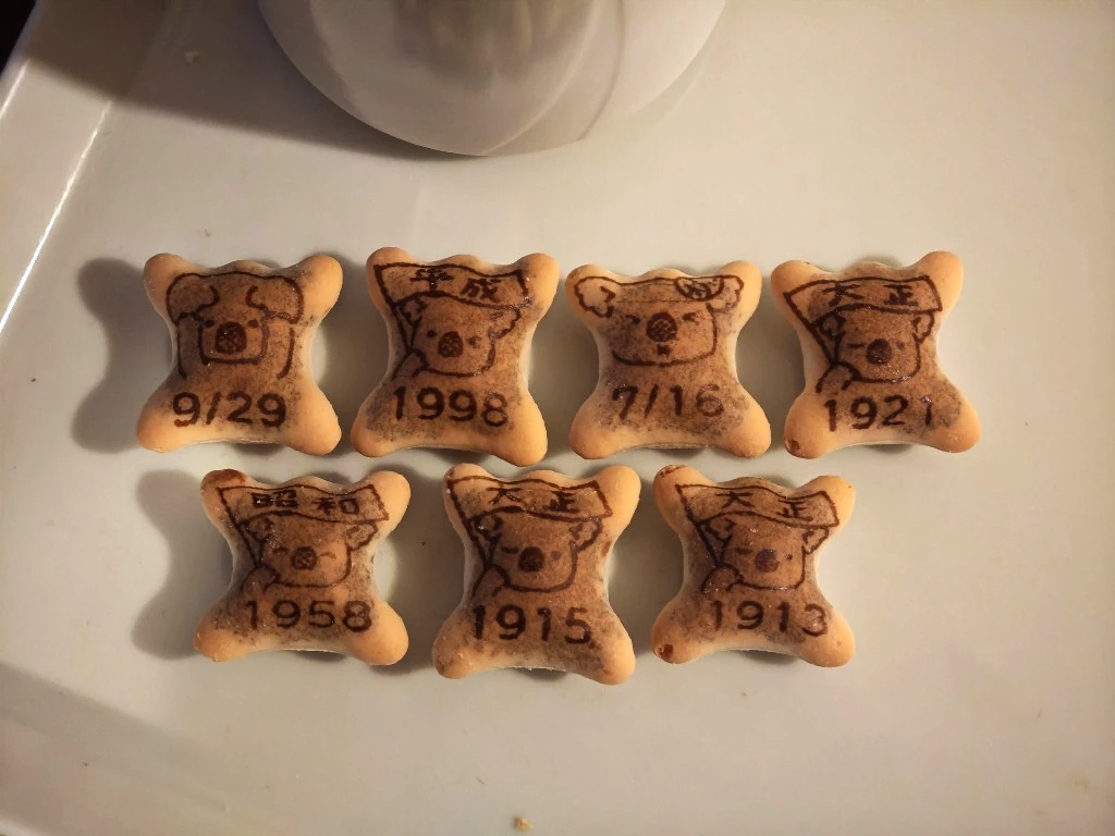 Seven Koala's March profile biscuits arranged for comparison