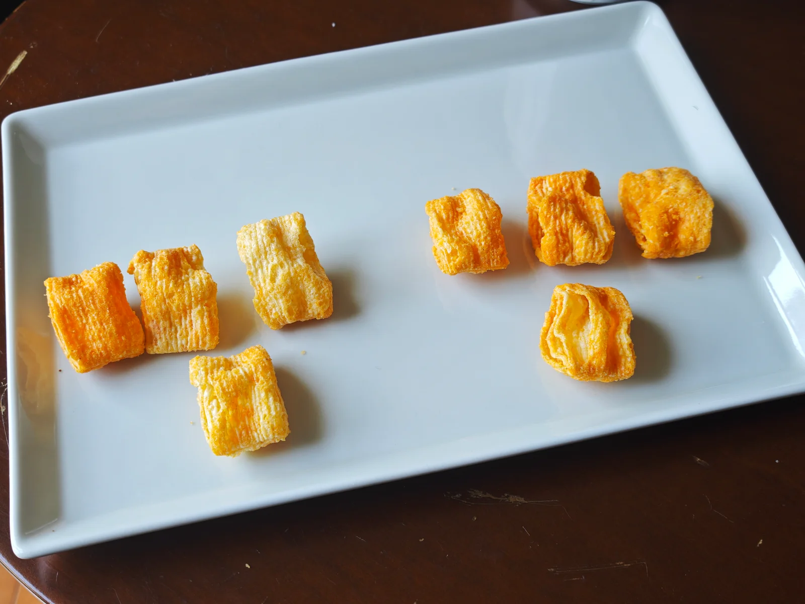 Seven Rich Cheese pieces on the left and YBC Rich Cheddar pieces on the right