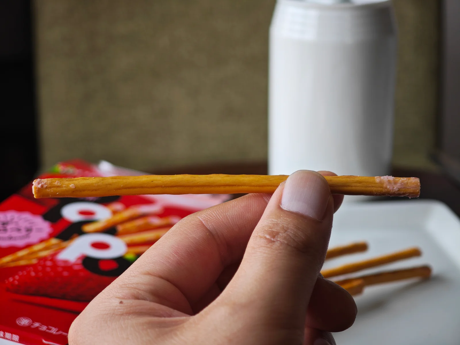 Side view of a curved strawberry Toppo stick with a katana-like arc
