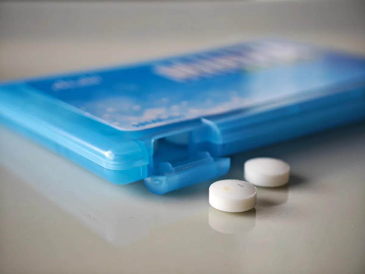 Two MINTIA Aqua Spark tablets beside the transparent blue case
