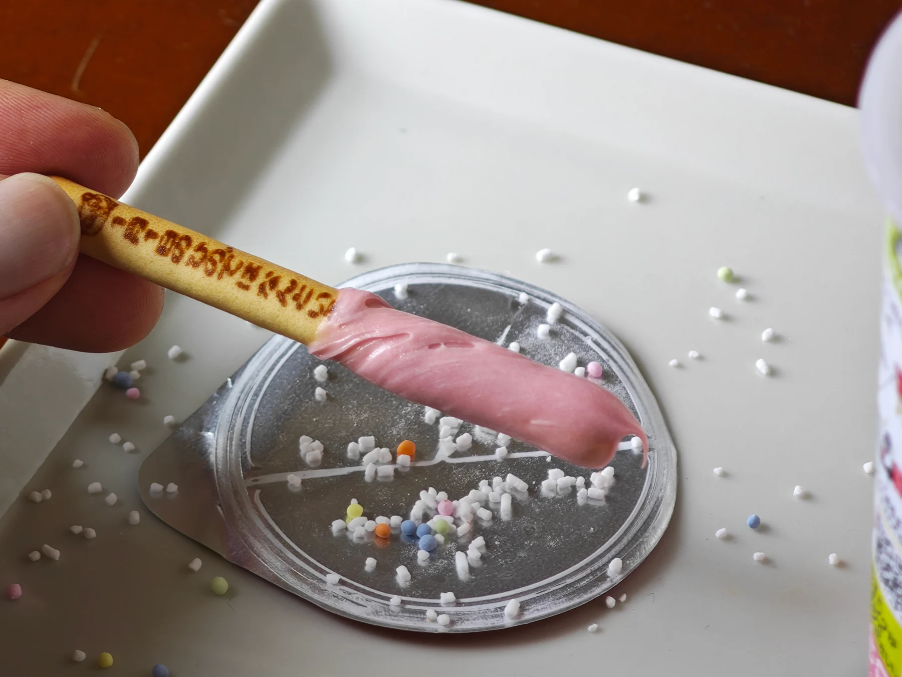 Strawberry cream coating on a Yan Yan cracker over the foil lid