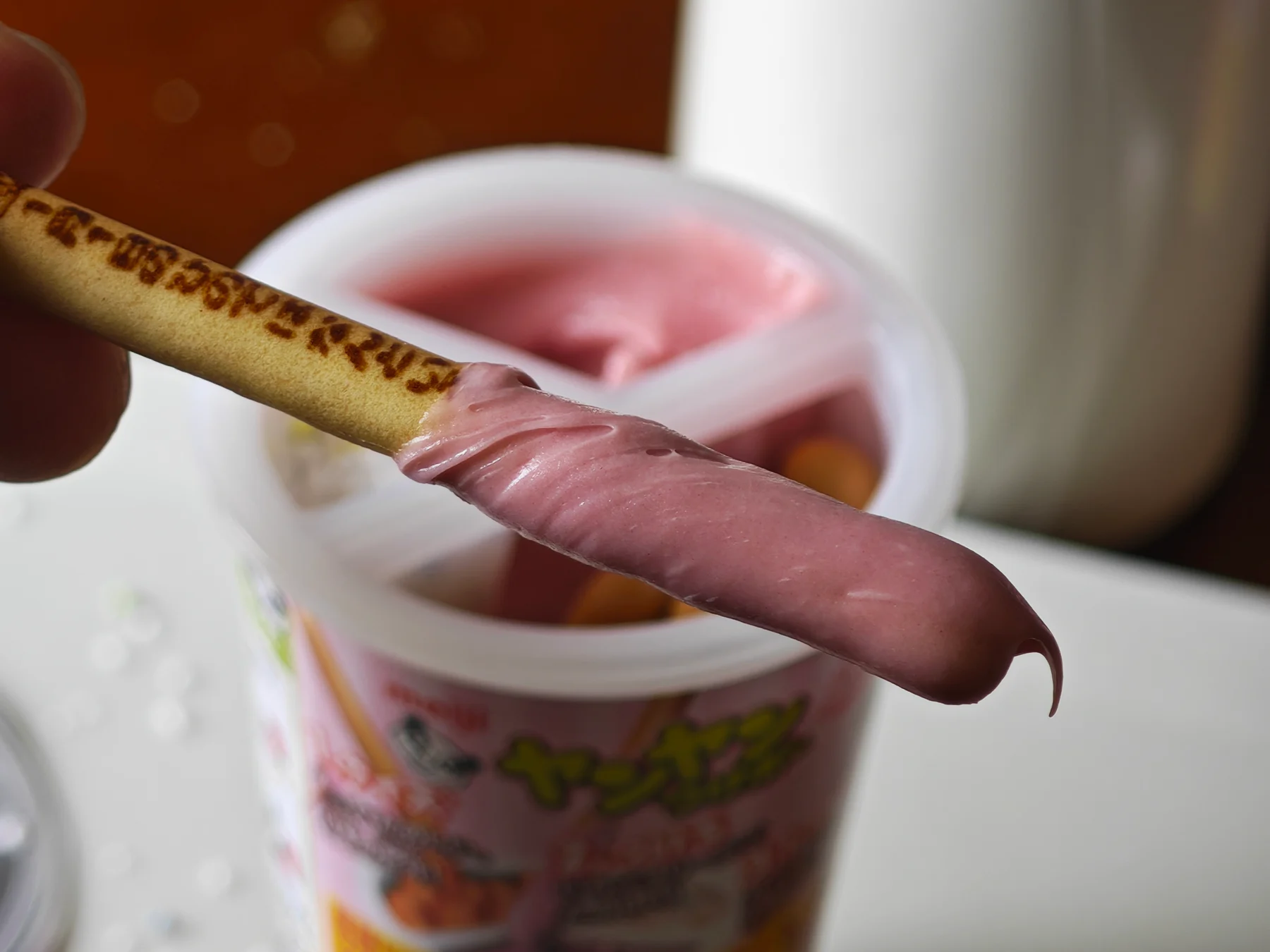 Close-up of a Yan Yan cracker dipped in strawberry cream