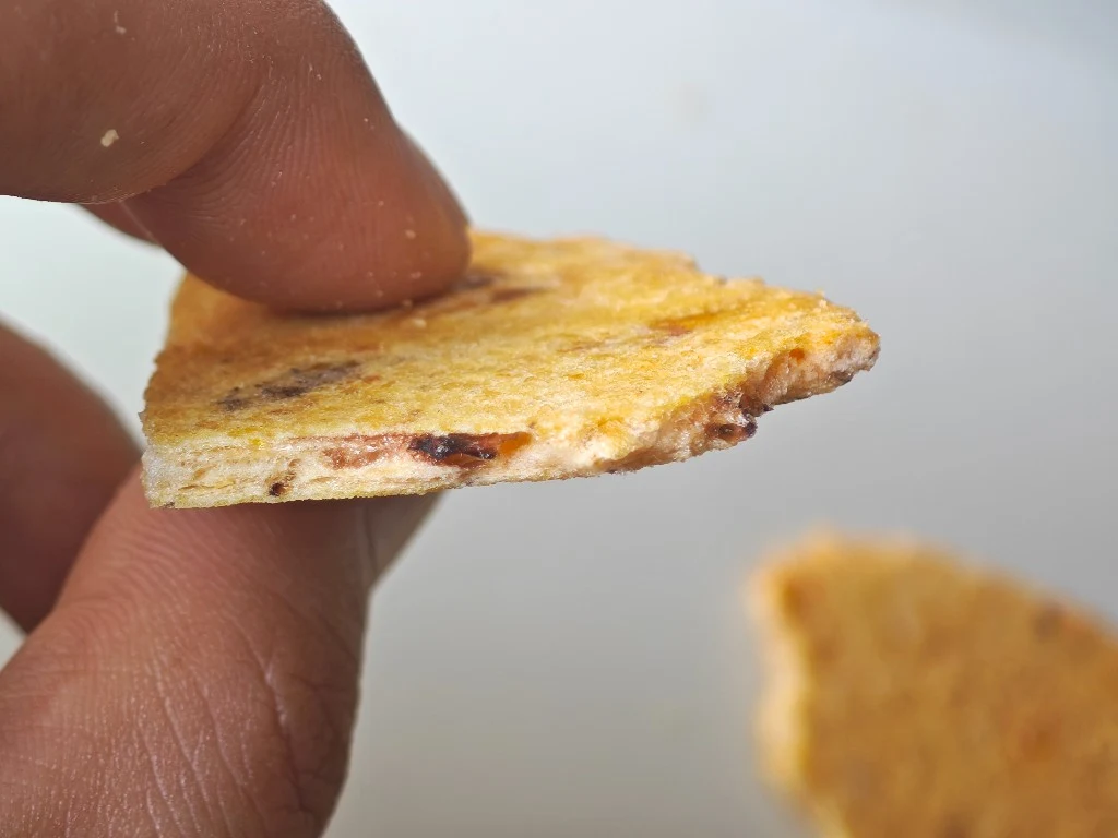 Broken Menbei cross-section with embedded seafood pieces visible in the dough