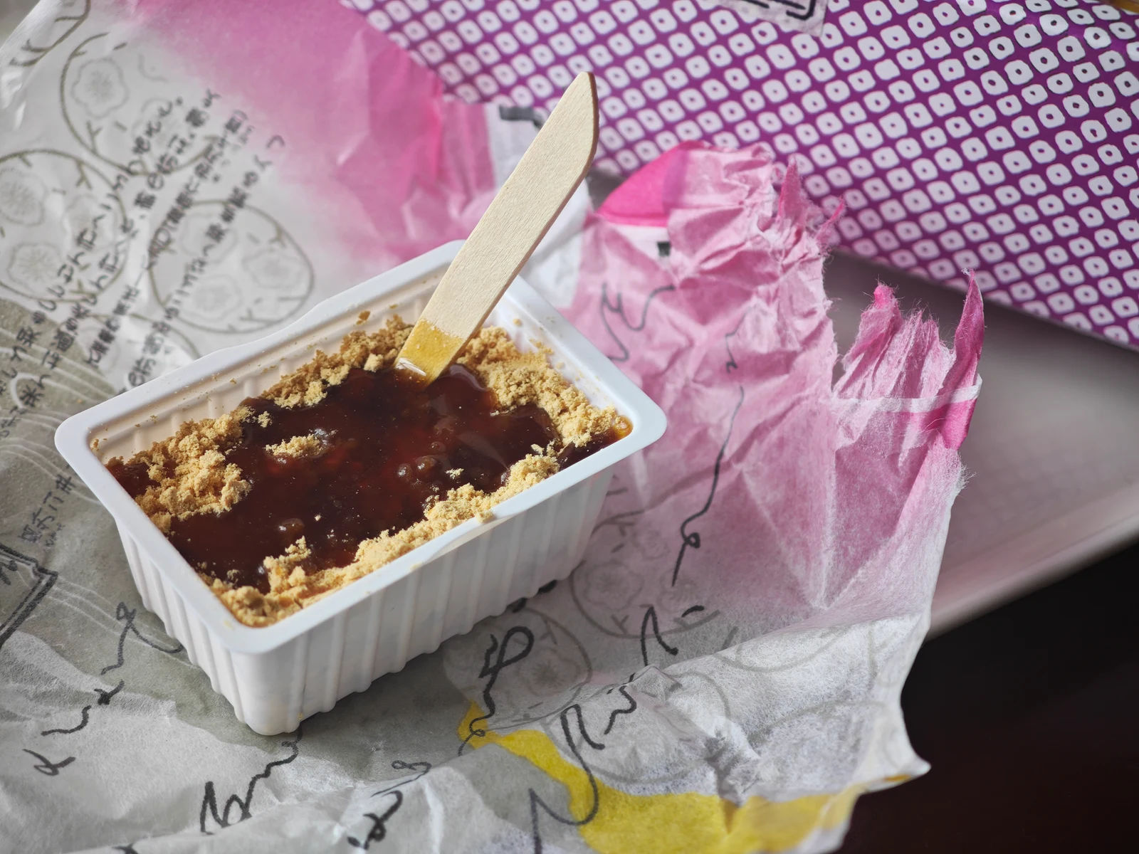 Kuromitsu poured over Tsukushi Mochi after opening channels in the kinako