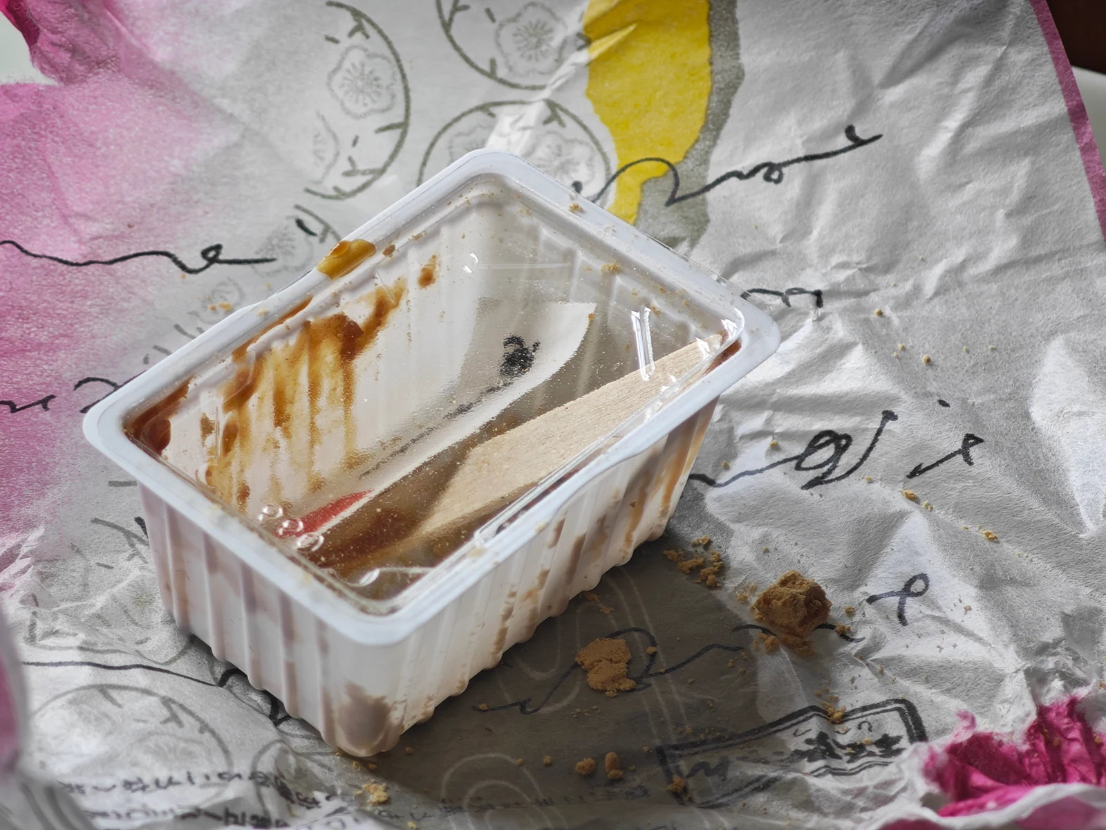 Empty Tsukushi Mochi tray closed with the used wooden pick inside