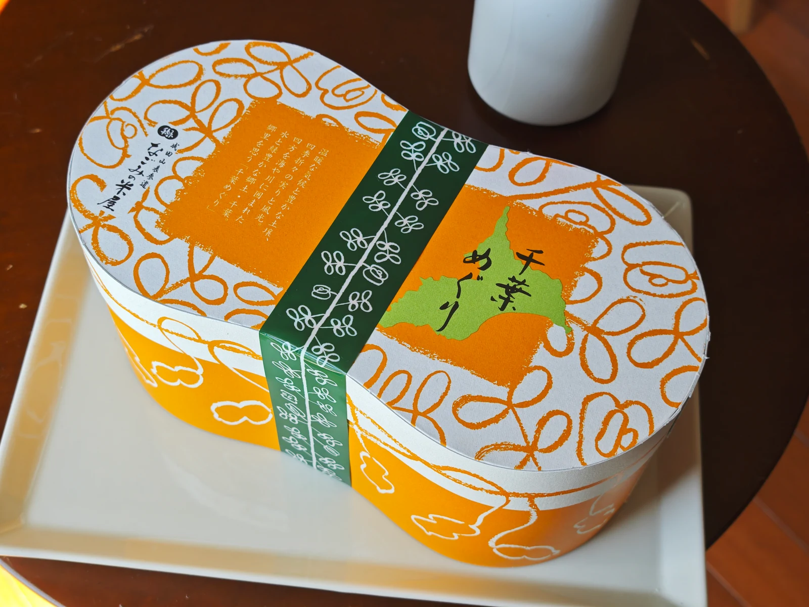 Chiba Meguri peanut-shaped gift box with an orange vine pattern and a green Chiba map illustration
