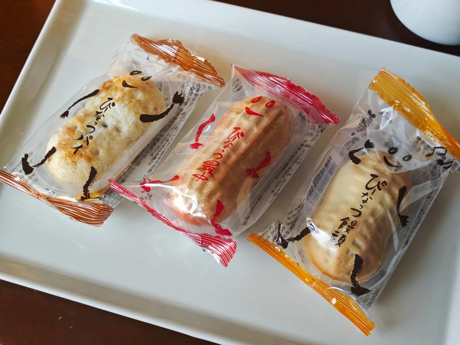 Peanut Pie, Peanut Monaka, and Peanut Manju in their character wrappers on a white tray