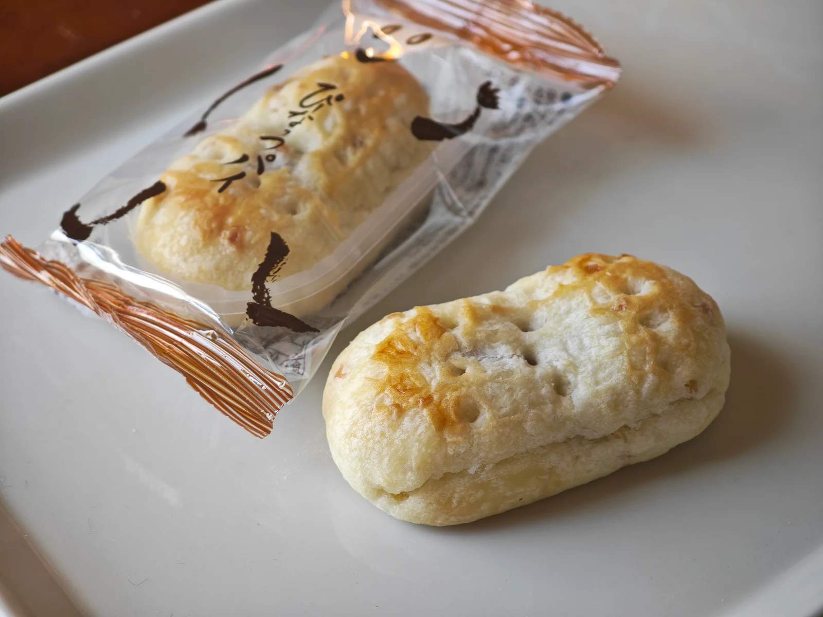 Unwrapped Peanut Pie with a flaky golden top beside its copper-brown package