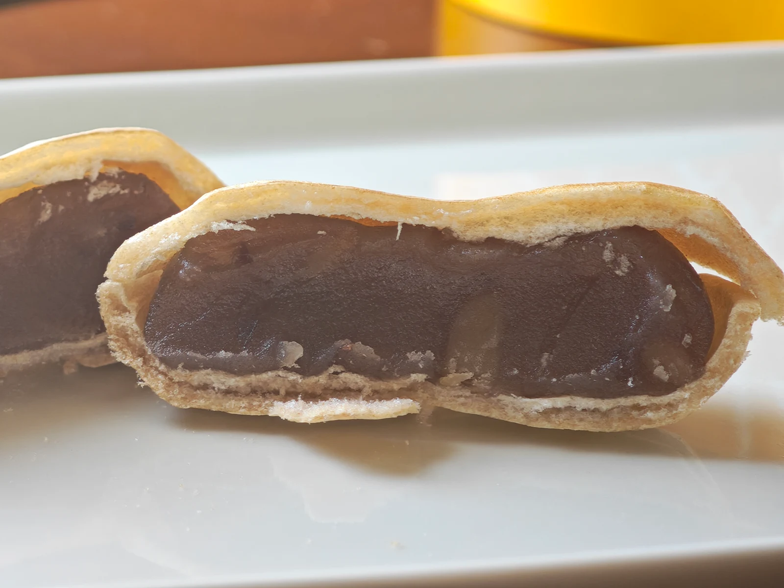 Cross-section of Peanut Monaka showing a thin wafer around dense brown peanut bean paste